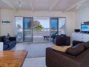 a living room with two couches and a television at Seaview Getaway in Dunbogan