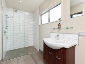 uma casa de banho com um lavatório e um chuveiro em Lake Views on Yewlett - Queenstown Holiday Home em Queenstown