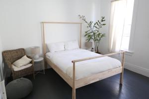 a bedroom with a bed and a chair and window at The Burlington in Los Angeles