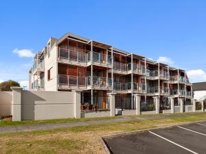 an apartment building with balconies and a parking lot at Roberts Retreat - Taupo Holiday Home in Taupo