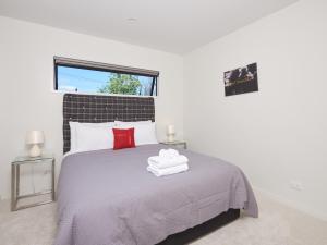 - une chambre avec un lit et 2 serviettes dans l'établissement Southern Lakes Spa - Queenstown Apartment R2, à Queenstown