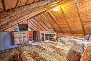 a room with two beds and a television in it at Authentic Log Cabin with Fire Pit, Pond, and More! in Broken Bow