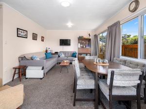 ein Wohnzimmer mit einem Tisch und einem Sofa in der Unterkunft Central Riverside Retreat - Taupo Holiday Home in Taupo