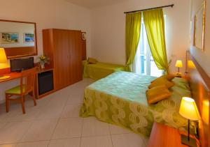 a bedroom with a bed and a desk and a television at Hotel Solaria in Rodi Garganico