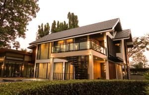 una casa grande con muchas ventanas en Paklop Resort, en Lopburi