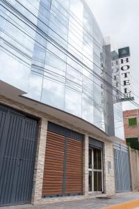 une façade en verre d'un bâtiment avec garage dans l'établissement Hotel Don Bartolo, à Espinar