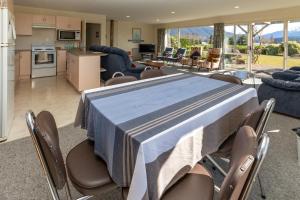 a kitchen and living room with a table and chairs at Kepler Retreat - Te Anau Holiday Home in Te Anau