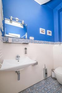 a bathroom with a white sink and a blue wall at Hotel 108 in Hamburg