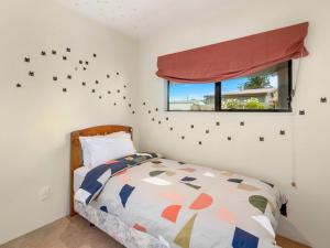a bedroom with a bed and a window at Mokoia Sunrise - Lakefront Ngongotaha Holiday Home in Ngongotaha
