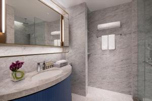 a bathroom with a sink and a mirror at Ascott Raffles City Chongqing in Chongqing