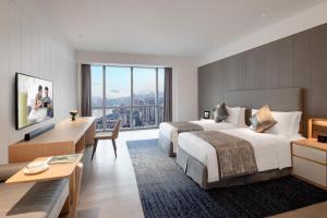 a hotel room with two beds and a desk at Ascott Raffles City Chongqing in Chongqing