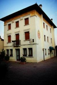 un grand bâtiment blanc avec un toit noir dans l'établissement Albergo La Meridiana, à Portogruaro