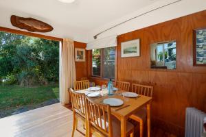 a wooden dining room with a table and chairs at North Cole Cottage - Hatepe Lake Front Home in Waitahanui
