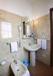 a bathroom with a sink and a toilet and a mirror at Hotel Natalina in Taormina