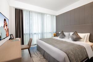 a hotel room with a large bed and a television at Ascott Raffles City Chongqing in Chongqing