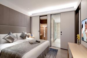 a bedroom with a large bed and a sliding glass door at Ascott Raffles City Chongqing in Chongqing