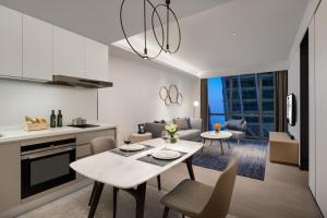 a kitchen and living room with a table and chairs at Ascott Raffles City Chongqing in Chongqing