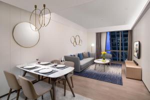 a living room with a table and chairs and a couch at Ascott Raffles City Chongqing in Chongqing