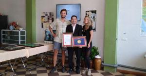 a man and a woman holding a plaque with a man holding a certificate at Dong Loan Hotel in Bản Na Bâ