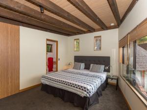 En eller flere senger på et rom på Crows Nest - Queenstown Holiday Home