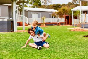 two young girls playing in the grass in a yard at Torquay Foreshore Caravan Park in Torquay