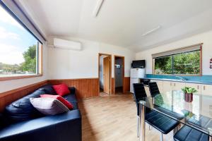 a living room with a couch and a glass table at Torquay Foreshore Caravan Park in Torquay