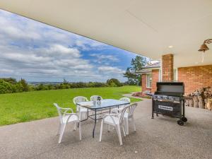 a patio with a table and chairs and a grill at Matakana Views - Matakana Holiday Home in Matakana