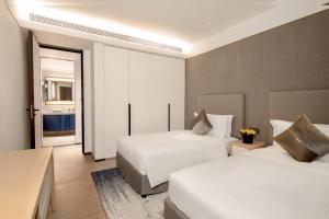 a hotel room with two beds and a window at Ascott Raffles City Chongqing in Chongqing