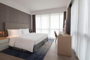 a hotel room with a bed and a television at Ascott Raffles City Chongqing in Chongqing