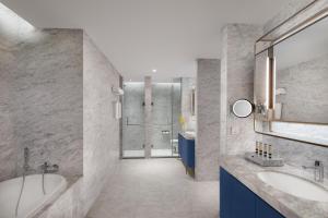 a bathroom with two sinks and a shower at Ascott Raffles City Chongqing in Chongqing