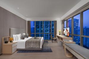 a bedroom with a large bed and a large window at Ascott Raffles City Chongqing in Chongqing