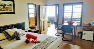 a bedroom with a bed and a desk and chairs at Golden Point Resort in Rakiraki +68 photos