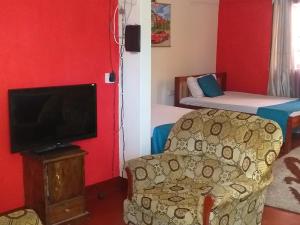 a room with a couch and a tv and a bed at CDH Backpackers in Mombasa