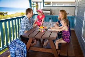 a group of people sitting at a table on a porch at Bulli Beach Tourist Park in Bulli