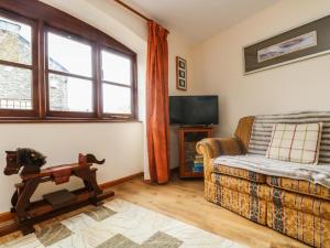 a living room with a couch and a tv at The Wagon House in Launceston