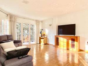 ein Wohnzimmer mit einem Sofa und einem Flachbild-TV in der Unterkunft Chalet Port de Roses in Roses