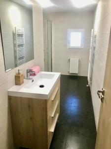 ein Badezimmer mit einem weißen Waschbecken und einem Spiegel in der Unterkunft Chalet Medina del Campo entrepinares in El Campillo