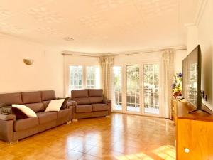 a living room with two couches and a television at Chalet Port de Roses in Roses