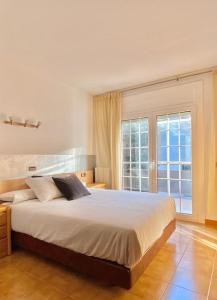 ein Schlafzimmer mit einem großen Bett und einem großen Fenster in der Unterkunft Chalet Port de Roses in Roses