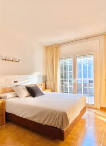 ein Schlafzimmer mit einem großen Bett und einem großen Fenster in der Unterkunft Chalet Port de Roses in Roses