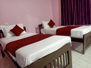 two beds with red and white sheets in a room at Rendezvous Place- Luxurious apartment in Varca