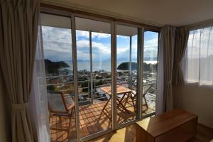 a room with a balcony with a view of a city at MY LODGE Naoshima in Naoshima