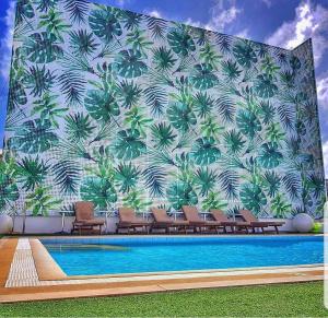 a mural of palm trees on a wall next to a swimming pool at The Tides Hotel Boracay in Boracay