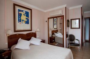 a hotel room with a bed and a mirror at Hotel La Residencia in Cadaqués