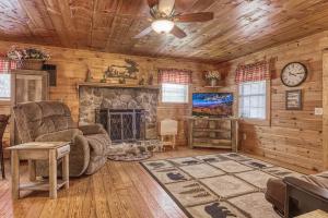 a living room with a fireplace in a log cabin at Bear Den in Sevierville