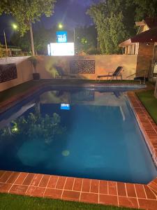 a large swimming pool at night with chairs in a yard at Albury City Motel in Albury