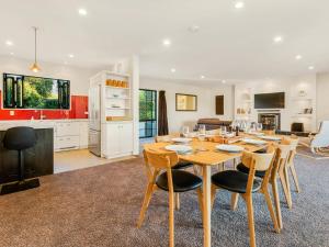 a kitchen and living room with a wooden table and chairs at Willowridge Escape - Wanaka Holiday Home in Wanaka