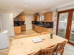 a large kitchen with a wooden table and chairs at Bryn Seion in Llanddeiniolen
