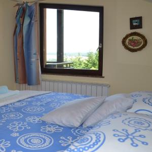 um quarto com uma cama azul e branca e uma janela em Green Zelina em Šulinec