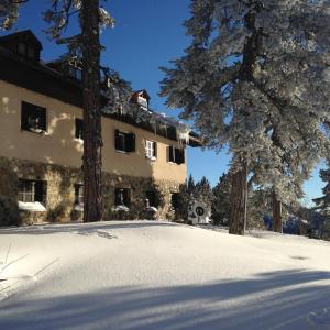 a building with snow in front of it at Jubilee Hotel Troodos in Troodos